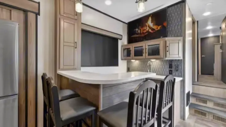 This modern RV rental offers a well-equipped kitchen and dining bar with stylish stools. Enjoy comfortable living on the road.. Crossroads RV Cameo 2022