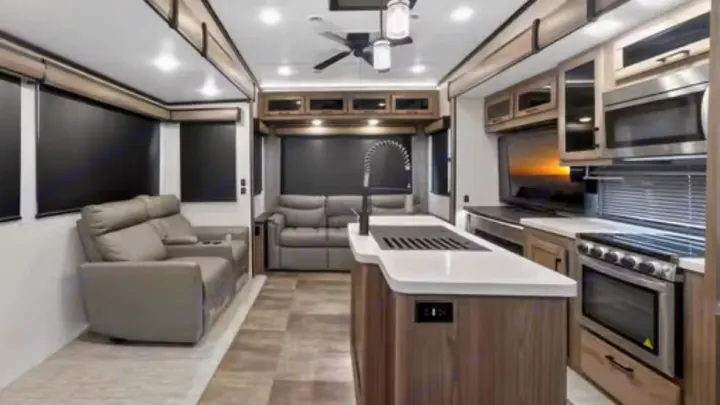 This RV rental showcases a bright, modern interior with a comfy living area, functional kitchen island, and appliances.. Crossroads RV Cameo 2022