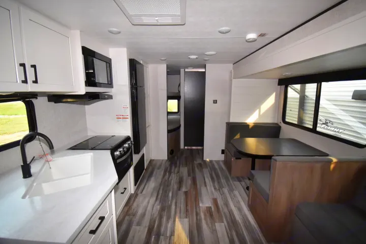 This bright rv rental interior features a modern kitchen, comfortable dinette, and bunk beds, perfect for family trips.. Jayco Jay Flight SLX 2025
