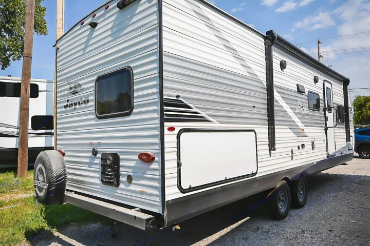 A white and grey Jayco Jay Flight travel trailer, excellent for your next RV rental, parked on gravel.. Jayco Jay Flight SLX 2025