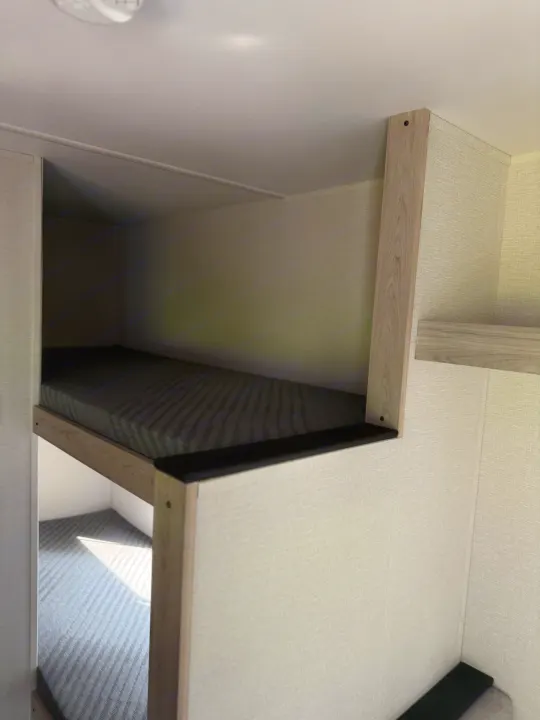 This RV rental features a cozy sleeping area with sturdy bunk beds and comfortable mattresses, ideal for family travel.. Heartland's RV Mallard 17 BHL 2025