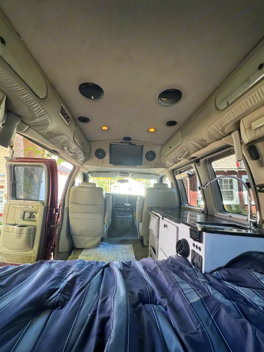 Inside this RV rental: a comfy bed, built-in kitchenette, TV, and spacious van interior for your adventure.. Chevrolet Open Road 2005