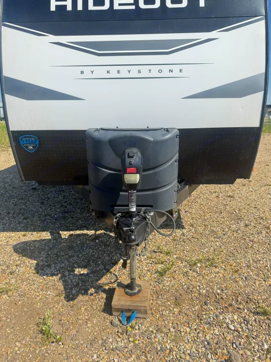 This Keystone Hideout RV rental front shows the hitch setup, dual propane tanks, and structural warranty details.. Keystone RV Hideout 2023