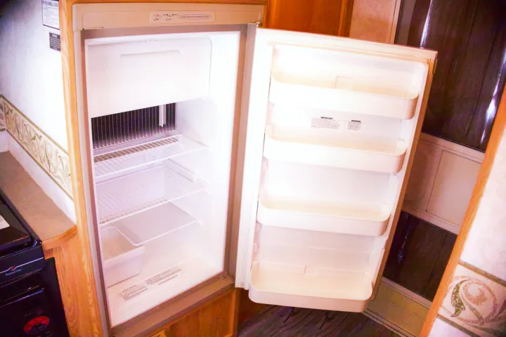 Open, empty RV rental refrigerator, featuring shelves and a top freezer compartment.. R-Vision Trail-Lite 2002