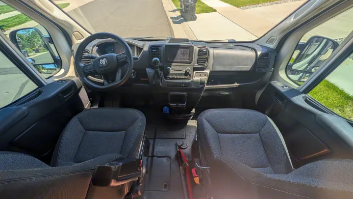 Interior of an RV rental: front cabin view with dashboard, steering wheel, and front seats, ready for adventure.. Dodge Ram 1500 2022