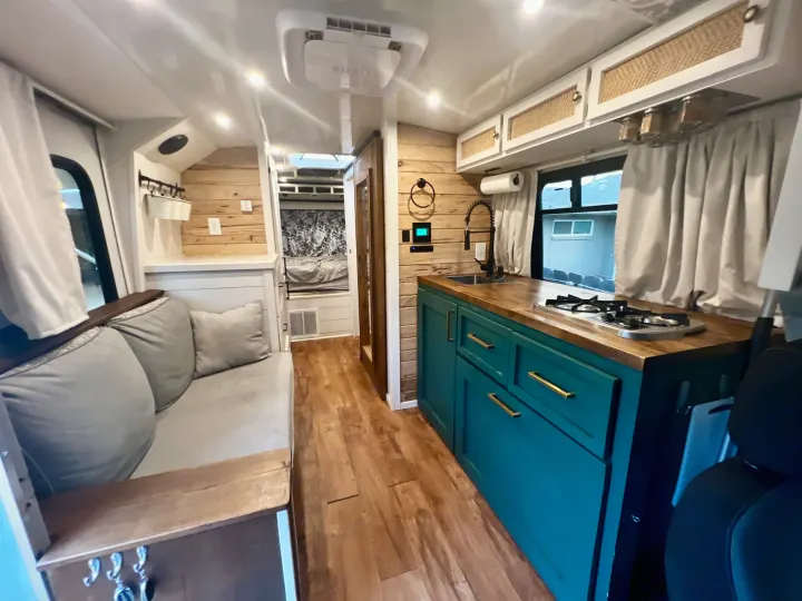 Explore this stylish rv rental: a cozy camper van with a teal kitchen, wooden accents, and comfy seating for your adventures.. Chevy C4500 Kodiak 2008