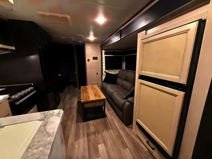 Enjoy this rv rental's spacious interior: full kitchen, comfy living area with sofa, and bunk beds for extra sleeping.. Jayco Jay Feather 2023