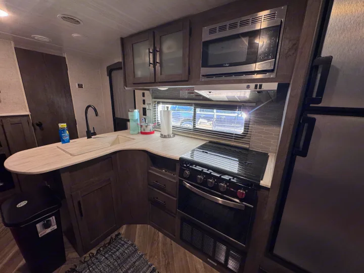 RV rental kitchen: a compact, fully equipped space with a sink, stove, oven, microwave, and storage for your road trips.. Forest River Salem Cruise Lite 2022