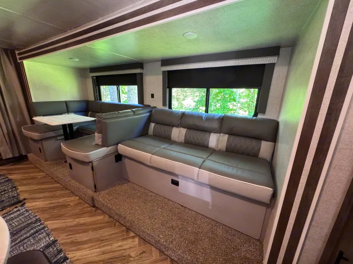 Modern RV rental living space with a U-shaped dinette, sofa, large windows, and stylish interior design.. Forest River Salem Cruise Lite 2022
