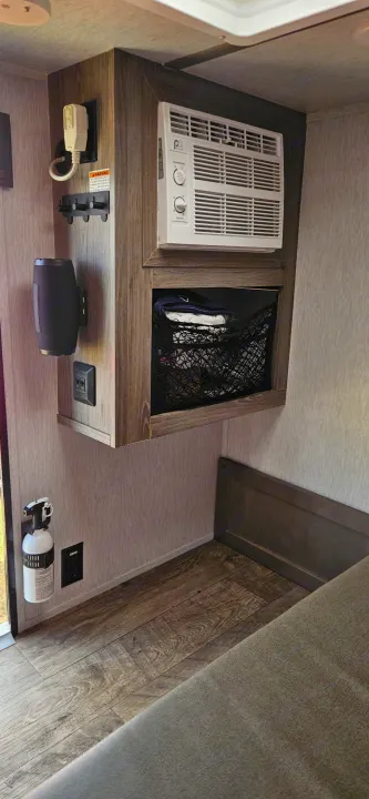 Practical RV rental interior: features include AC, speaker, storage net, and fire extinguisher for a safe, comfortable trip.. Sunset Park RV SunRay 2024