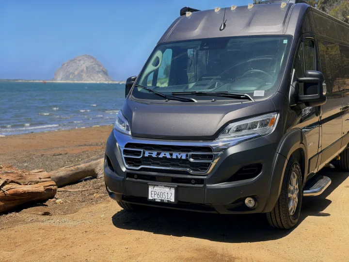 Grey Ram ProMaster RV rental parked on a beach near Morro Rock, California. An ideal camper van for a scenic adventure.. Jayco Swift 2025
