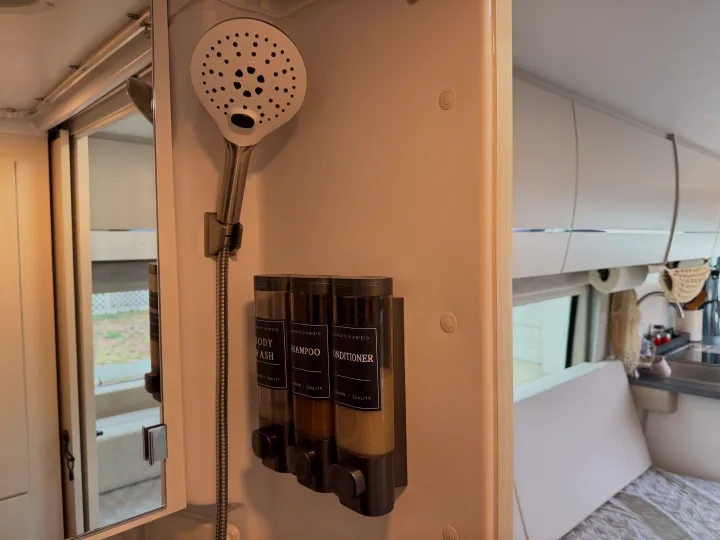 This RV rental's compact shower features a handheld showerhead and wall-mounted dispensers for body wash, shampoo, and conditioner.. Jayco Swift 2025