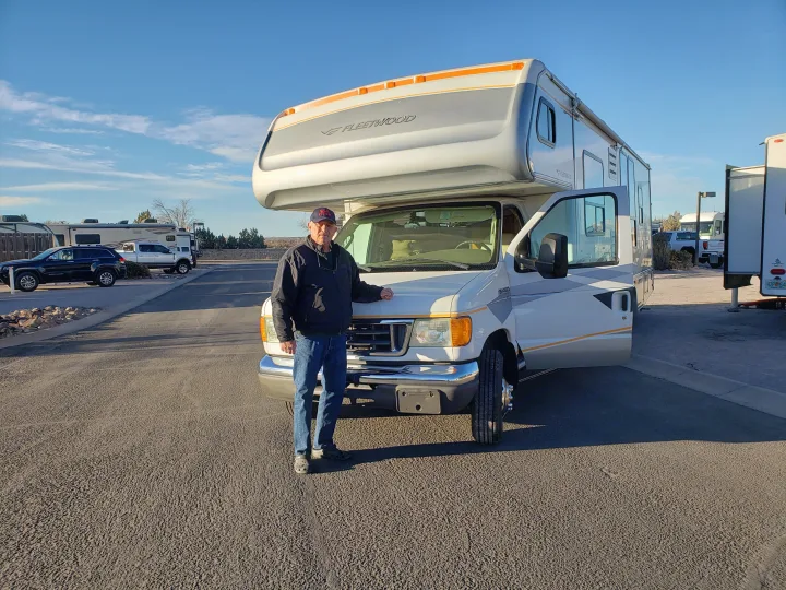 A man poses with a white Fleetwood Class C RV, an excellent choice for an rv rental vacation or road trip.. Fleetwood Tioga 31M 2007