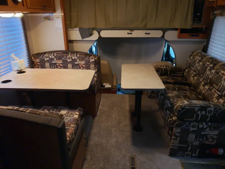 Cozy RV rental interior showing dinette, couch, and bunk area for a comfortable journey.. Fleetwood Tioga 31M 2007