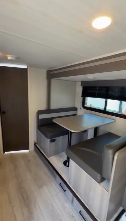 RV rental interior: A bright dinette with cushioned booth seating, a table, and under-seat storage. Ideal for travel.. Keystone RV Hideout Sport 2025