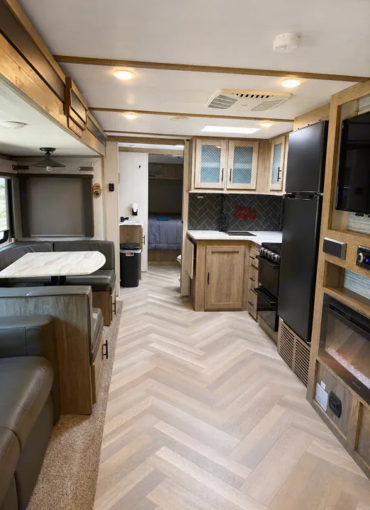 Spacious RV rental interior with a modern kitchen, living/dining area, and cozy bedroom for comfortable travel.. Forest River Salem 2021