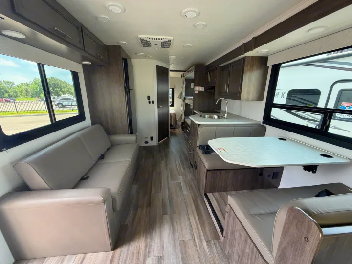 Modern rv rental interior: living area with sofa, dinette, and kitchen, ideal for road trip travel and comfort.. Jayco Redhawk SE 31FF 2026