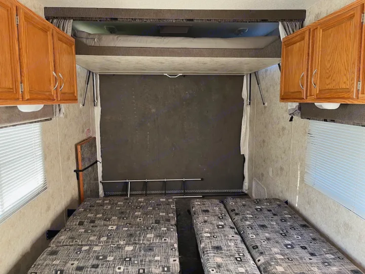 RV rental toy hauler interior: lower convertible beds, upper bunk bed, rear ramp wall, & wood cabinets. Ready for travel!. Eclipse Recreational Vehicles Attitude 2007