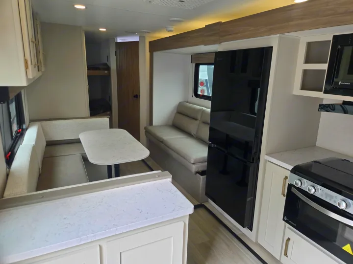 Modern RV rental interior with kitchen, dinette, and bunk beds, offering comfort for your next adventure.. KZ Sportsmen 291BHK 2027