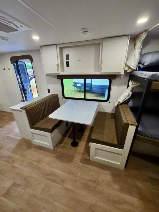 This RV rental features a practical dinette with bench seating, bunk beds, and an open entryway. Ideal for road trips.. Grand Design RV Transcend Xplor 26BHX 2027