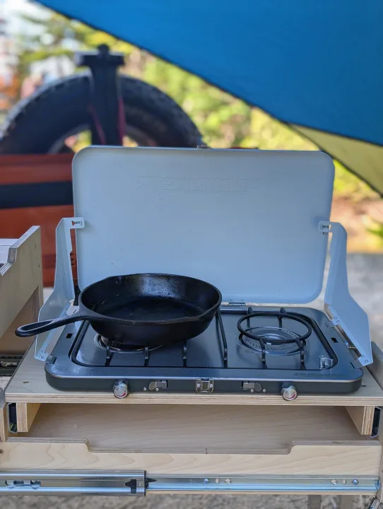 RV rental: Cast iron skillet on a Zempire camp stove in a pull-out outdoor kitchen setup, ideal for campervan adventures.. Jeep Wrangler 2012