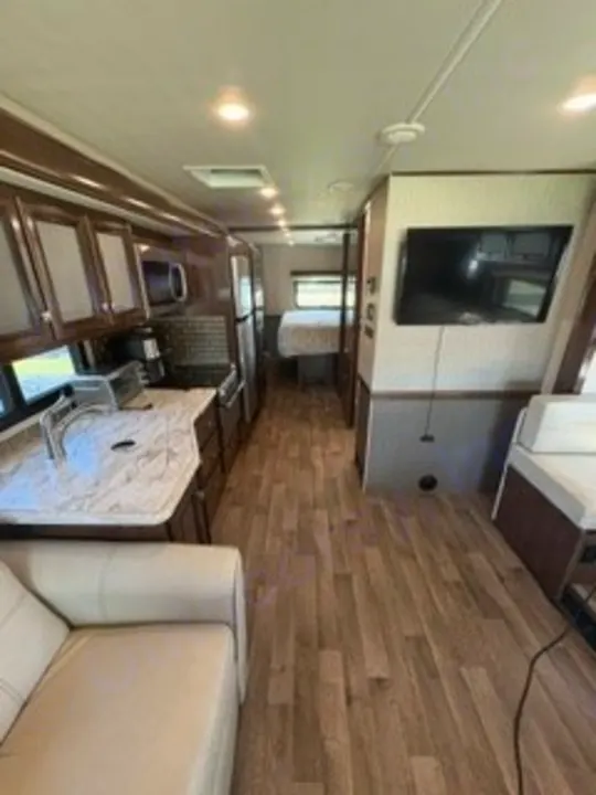 This rv rental offers a well-equipped kitchen, comfy living area, and back bedroom, all with modern wood flooring.. Fleetwood FLAIR 2020