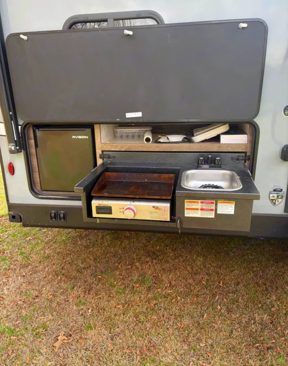 RV rental outdoor kitchen with fridge, grill, and sink for easy camping meals. Perfect for your next adventure!. Venture Venture Trailer 2023