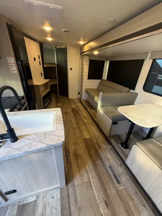 Modern RV rental interior: kitchen, dinette, and cozy living space with bunk beds for a comfortable travel experience.. Crossroads RV Sunset Trail Sport 2025