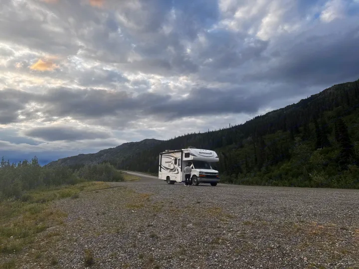 Enjoying an RV rental adventure. Motorhome parked on a scenic mountain road under a cloudy sky.. Forest River Sunseeker LE 2018