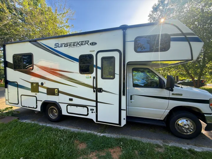This white Sunseeker Class C rv rental with blue/brown decals, on a Ford E-350 chassis motorhome, is ready for camping.. Forest River Other 2021