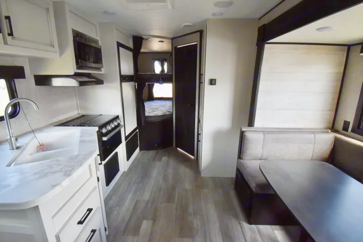 Modern RV rental interior with kitchen, dining booth, and bunk beds for comfortable travel.. Jayco Jay Flight 2023