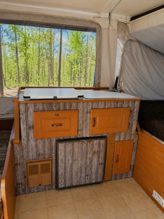 RV rental pop-up camper interior features kitchen, fridge, cabinets, and a scenic forest view from the window.. Coleman Santa Fe 2003
