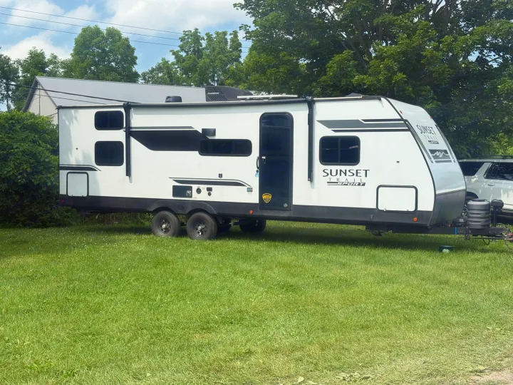 White Sunset Trail Sport RV rental, a travel trailer, sits on grass, ready for your next outdoor adventure.. Crossroads RV Sunset Trail Sport 2025