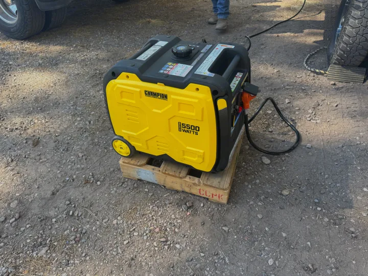 Portable yellow Champion 5500W inverter generator on a pallet, perfect for RV rental adventures on gravel.. Forest River Rockwood Geo Pro 2022
