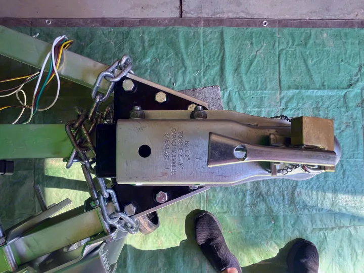 RV rental trailer hitch: Ball 2", 3500lbs capacity, with safety chains & wiring harness on a green tarp.. Custom Custom 2025