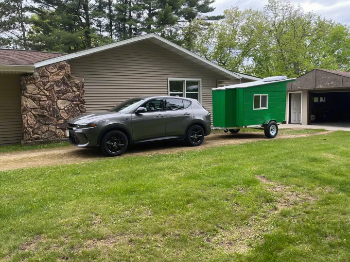 Gray SUV towing a bright green custom camper trailer on a driveway. Imagine this for an RV rental adventure!. Custom Custom 2025