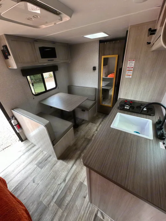RV rental interior showing a compact kitchen, dinette, and cozy living space. Perfect for travel!. Crossroads RV Zinger Lite 2026