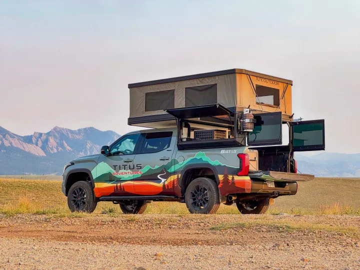 This custom Titus Adventures overland RV rental pickup, equipped with a rooftop tent, is ready for outdoor exploration.. Toyota Tundra 2026