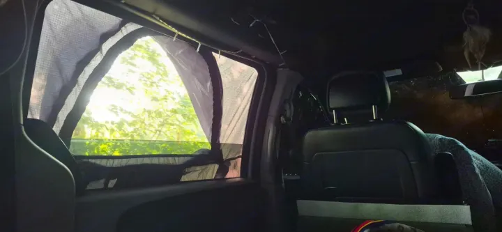 RV rental interior: Sunlight filters through mesh window screens into a modified van, ideal for camping or travel.. Dodge Grand Caravan 2017