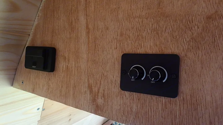 RV rental van interior: A black ON/OFF switch and two rotary fan/light controls are mounted on light wood paneling.. Ford Econoline 2011