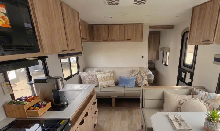 Bright rv rental interior: modern kitchen, cozy sofa, dining space, and wood cabinets. A functional home on wheels.. Winnebago Access 2025