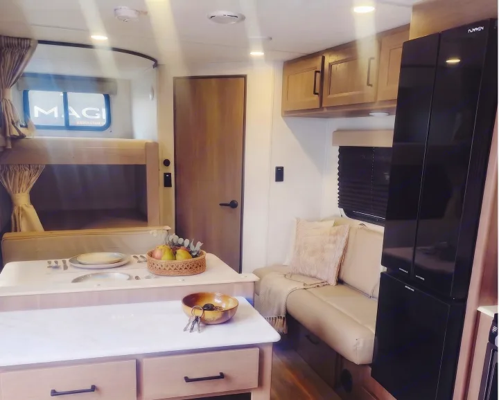 Explore this modern RV rental: a compact interior with bunk beds, dinette, comfy sofa, and sleek kitchen. Road trip ready!. Grand Design Transcend Xplor 2025