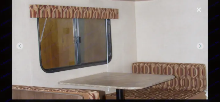 RV rental interior: dinette with patterned cushions & valance, and a window, ideal for compact living spaces.. KZ SPORTSMEN 2017
