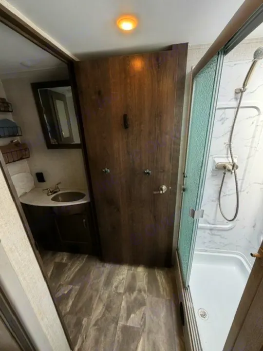 Explore this RV rental's efficient bathroom: full shower, vanity sink, and private toilet area. Modern interior for your journey.. Gulf Stream Conquest 2023