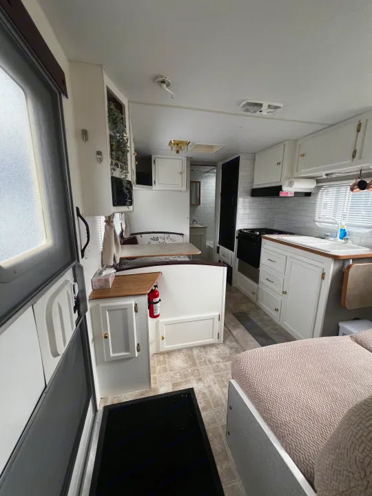 Bright rv rental interior: kitchen, dining booth, and bathroom. Functional and clean space from entry door.. Kustom Koach Westwind 2004