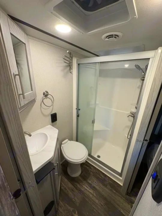 RV rental bathroom: A compact and functional space with a shower, toilet, sink vanity, and modern finishes.. Keystone Fuzion 2021