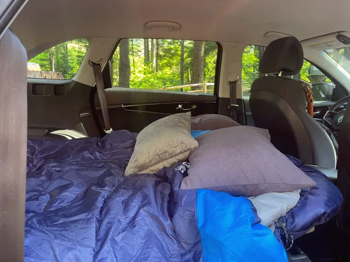 SUV transformed for car camping with a sleeping bag & pillows. Great alternative to an rv rental for forest adventures.. KIA Sorento 4X4 2017