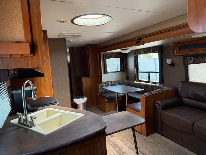 Comfortable RV rental interior showcasing a kitchen, dining booth, and sofa—ready for your next adventure.. Starcraft Autumn Ridge 2015