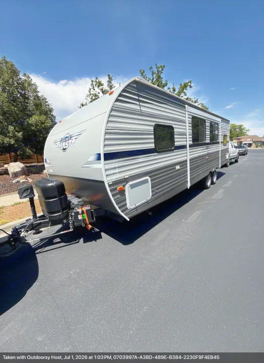 This gray and black Shasta RV rental travel trailer is parked on asphalt under a clear blue sky, ready for adventure.. Forest River Shasta 2021