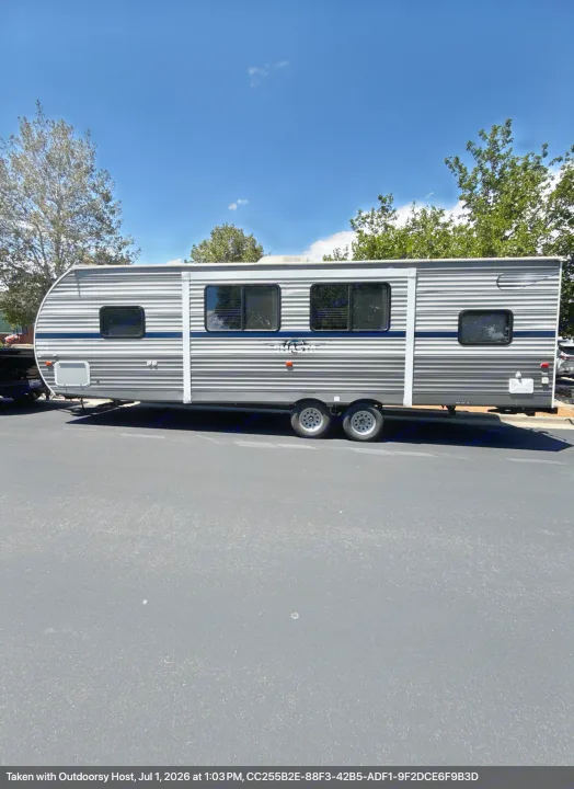 This travel trailer is available for rv rental! A spacious gray and white Shasta RV parked on asphalt on a sunny day.. Forest River Shasta 2021